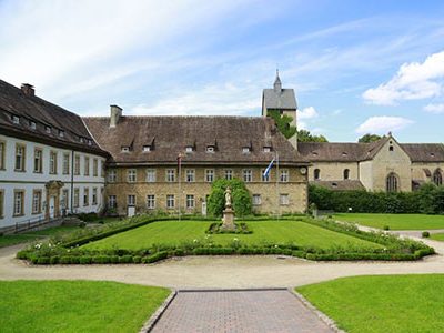 Innenhof des Hotel Schloss Gehrden, mit Rosengarten und Blick zur Kirche St. Peter und Paul.