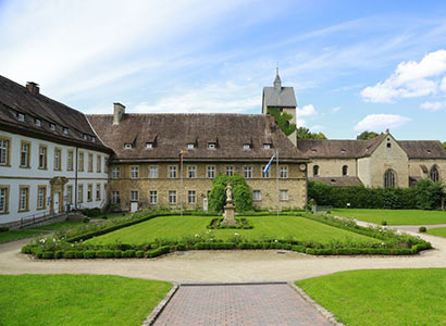 Innenhof des Hotel Schloss Gehrden, mit Rosengarten und Blick zur Kirche St. Peter und Paul.